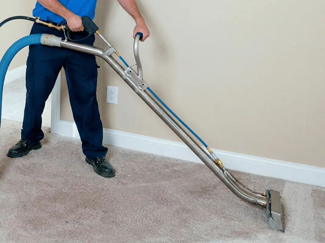Professional operating a liquid removal machine on a carpeted floor in Birmingham, AL